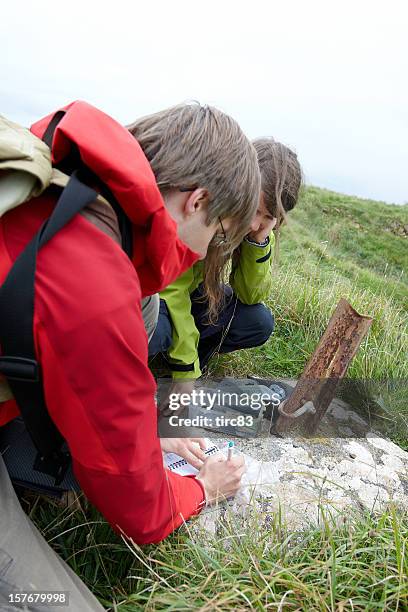 young man and woman geocaching - geocaching stock pictures, royalty-free photos & images