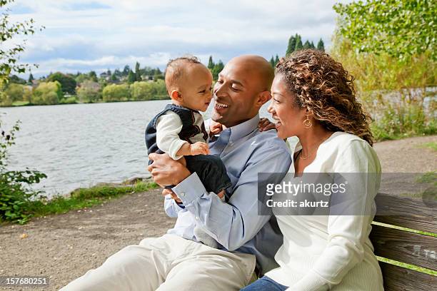 happy african american family playing outdoors with their baby boy - upper class stock pictures, royalty-free photos & images