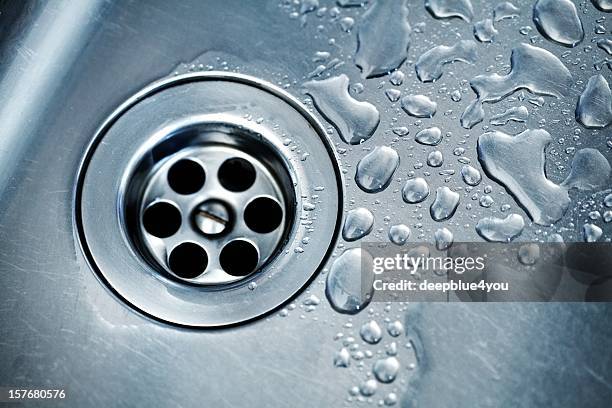 water drops around plughole - gootsteen stockfoto's en -beelden