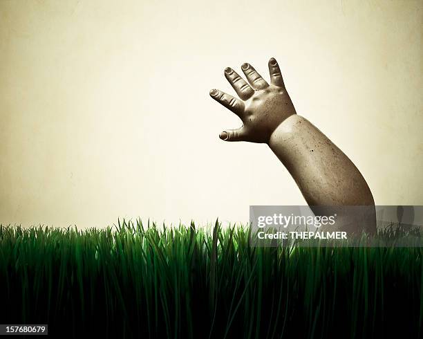 spooky muñeca mano salir de la hierba - doll fotografías e imágenes de stock