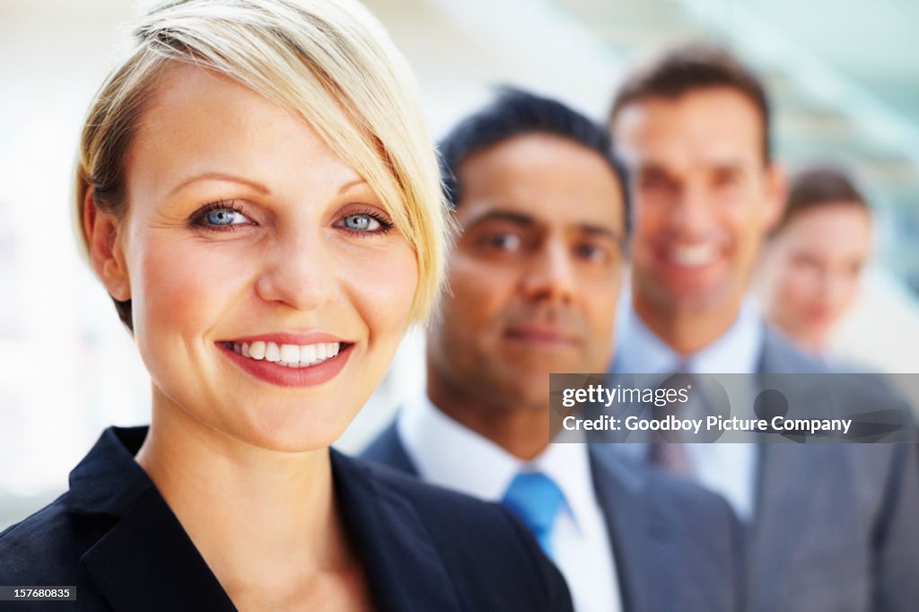 Businesswoman smiling with her team in the background