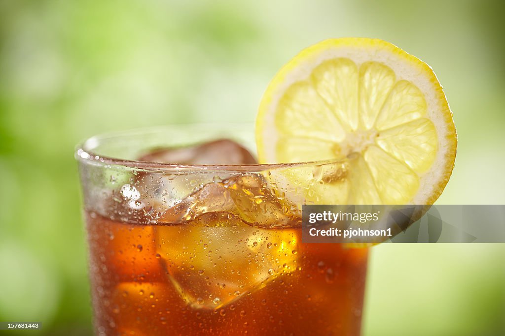 A close-up of a glass of iced tea with lemon