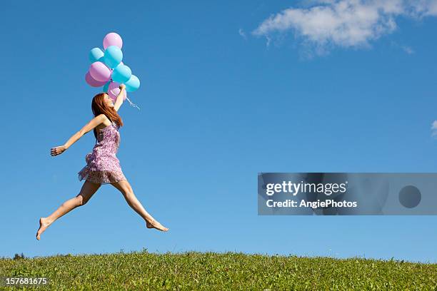 happy woman jumping with balloons - happy people running stockfoto's en -beelden