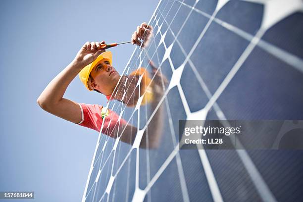 male worker at work fixing solar panel - solar panel installation stock pictures, royalty-free photos & images