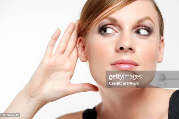 jeune femme avec la main de ventouses oreille et écouter d'une oreille indiscrète - tendre l'oreille photos et images de collection