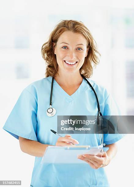 happy healthcare worker with notepad against blur background - blue coat stock pictures, royalty-free photos & images