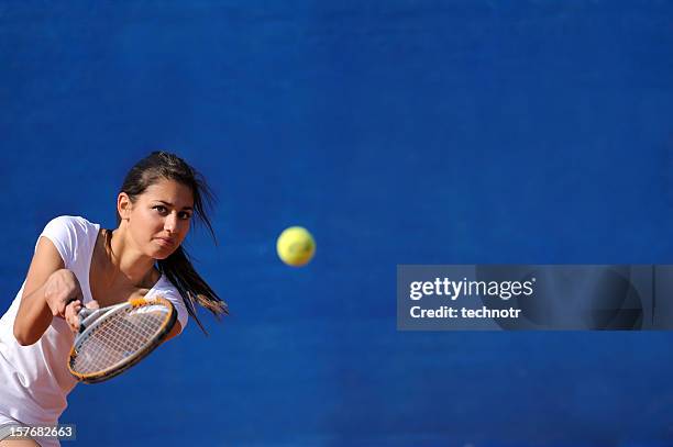 female tennis player at backhend drive - blue tennis court stock pictures, royalty-free photos & images