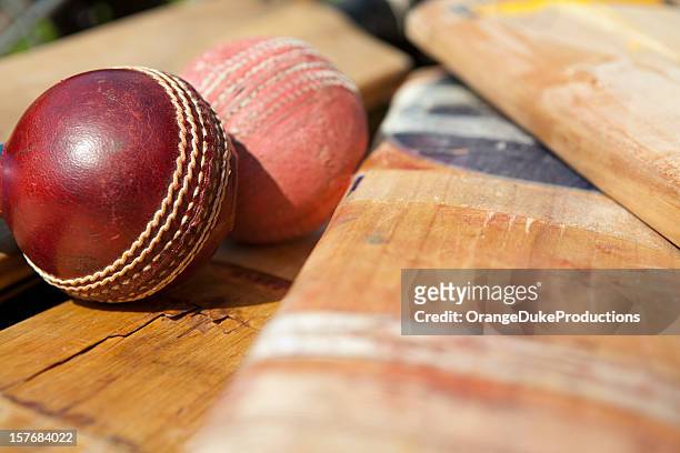 new and old cricket ball lying on bats - cricketbat stockfoto's en -beelden
