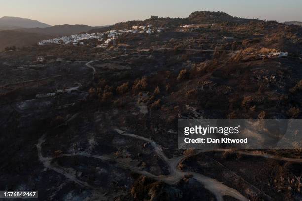 Charred landscape at sunset outside the village of Vati on July 28, 2023 in Vati, Rhodes, Greece. While firefighting planes and helicopters are still...