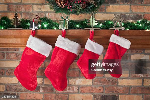 christmas, red stockings, brick wall, mantel, decorations - kousen stockfoto's en -beelden
