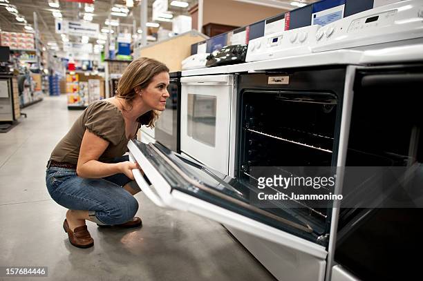 shopping for a new kitchen stove - appliance shop stock pictures, royalty-free photos & images