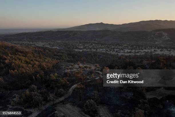Charred landscape at sunset outside the village of Vati on July 28, 2023 in Vati, Rhodes, Greece. While firefighting planes and helicopters are still...
