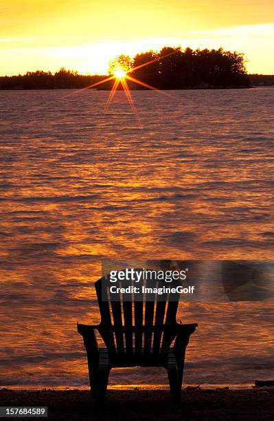 muskoka chair at the lake - muskoka stockfoto's en -beelden