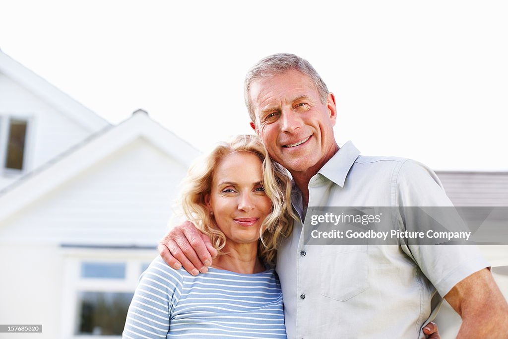 Senior man with a mature woman in front of house