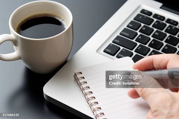 writing it in the spiral notebook at laptop - agenda meeting stock pictures, royalty-free photos & images