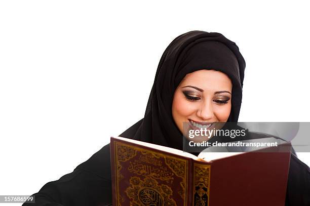 happy arabic girl reading the holy koran - reading v oman stockfoto's en -beelden