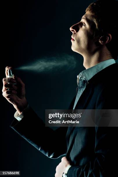 man spraying perfume - perfume stock pictures, royalty-free photos & images