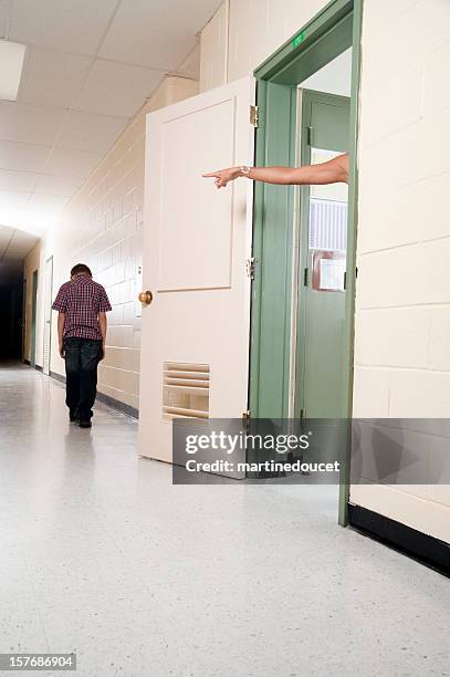 hand of teacher pointing a student out of classroom. - school punishment stockfoto's en -beelden