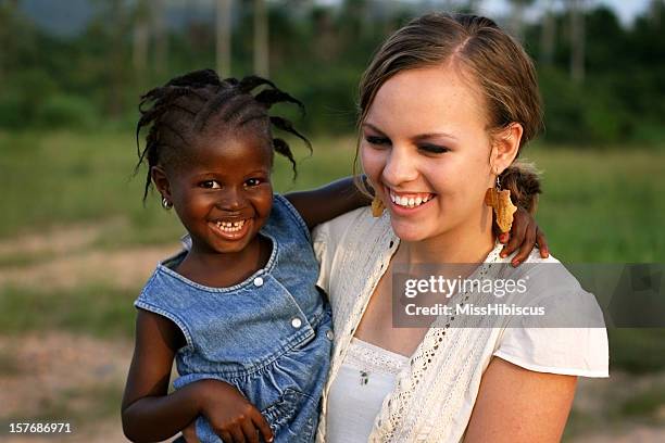 american woman holding african girl - miss sierra leone stock pictures, royalty-free photos & images