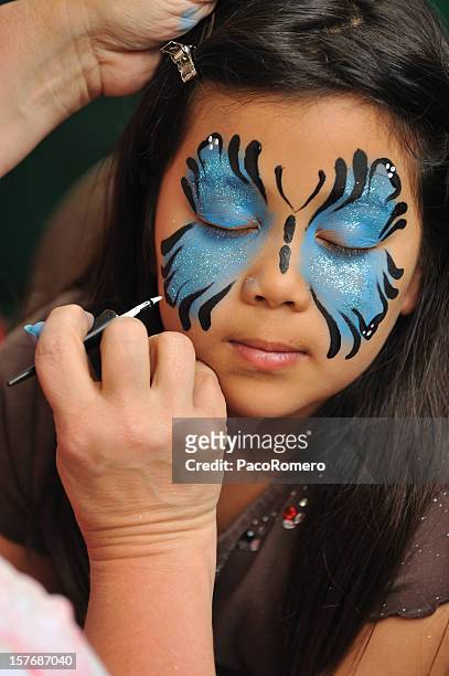 little girl having her face painted. - face paint stock pictures, royalty-free photos & images