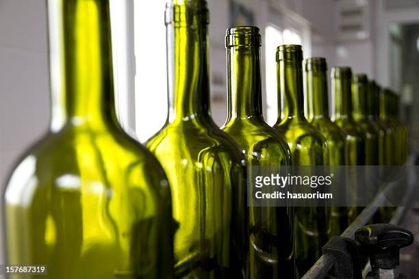 wine bottles colored green on an assembly line - iron wine stock pictures, royalty-free photos & images