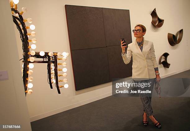 Evelina Khromtchenko looks at the art in a gallery as Art Basel opens at the Miami Beach Convention Center on December 5, 2012 in Miami Beach,...