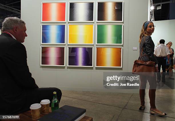 People look at art in the Paragon Press gallery as Art Basel opens at the Miami Beach Convention Center on December 5, 2012 in Miami Beach, Florida....