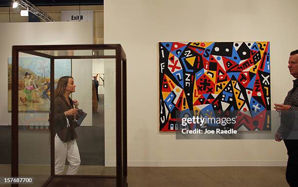 People look at art in a gallery as Art Basel opens at the Miami Beach Convention Center on December 5, 2012 in Miami Beach, Florida. The 11th edition...