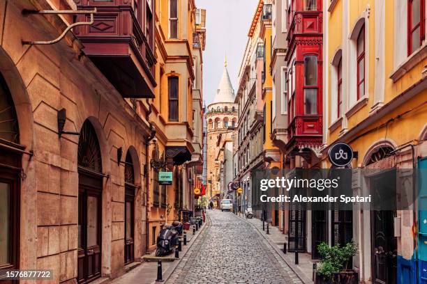 narrow street with galata tower and historic building in beyoglu district, istanbul, turkey - istanbul stock-fotos und bilder