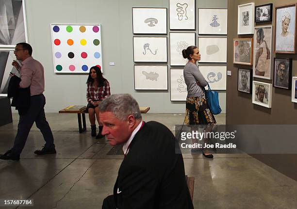 People look at art in the Paragon Press gallery as Art Basel opens at the Miami Beach Convention Center on December 5, 2012 in Miami Beach, Florida....