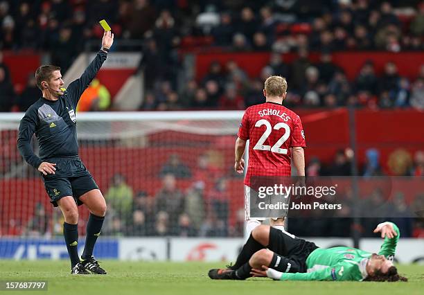 Paul Scholes of Manchester United is booked for a foul on Matias Aguirregaray of CFR 1907 Cluj during the UEFA Champions League Group H match between...