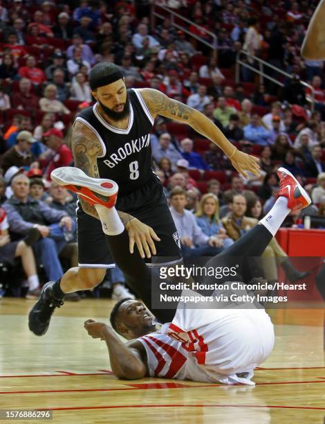 Houston Rockets forward Terrence Jones is blocked by Brooklyn Nets guard Deron Williams while trying to score during the first half of the basketball...