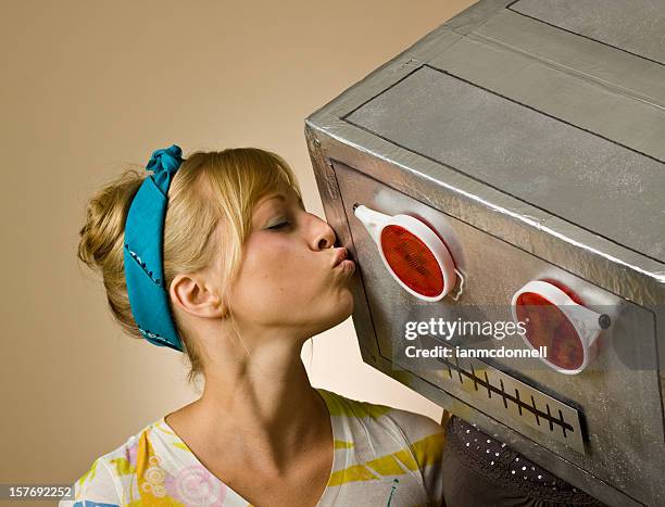 close-up of woman in striped shirt kissing robot - human robot stock pictures, royalty-free photos & images