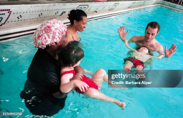 View of swim instructor Jim Spiers as he teaches a young boy to float during a Toddler's Swim Class at Aerobics West, New York, New York, July 16,...