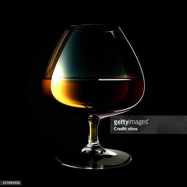 glas brandy gegen dunklen hintergrund - cognac glass stock-fotos und bilder