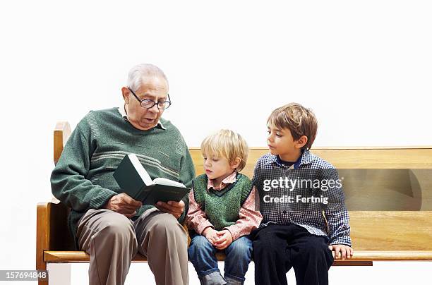 grandfather reading the bible to his grandsons - evangelicalism stock pictures, royalty-free photos & images