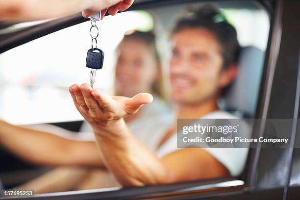 blurred couple with man receiving car key from salesman - car passion stock pictures, royalty-free photos & images