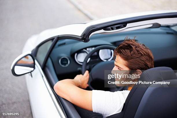 alto ángulo de atractivo joven hombre en la velocidad de conducción convertible - convertible car fotografías e imágenes de stock