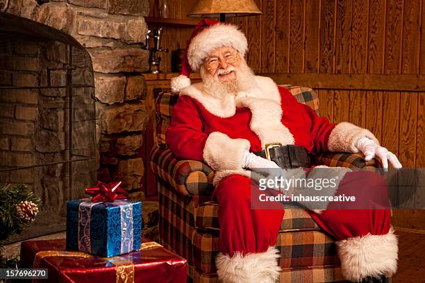 pictures of real santa claus relaxing at home - sitting by fireplace stock pictures, royalty-free photos & images