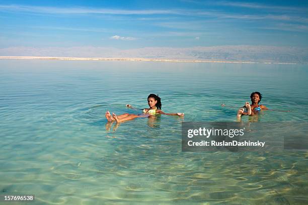 girls floating in salty water. - israel travel stock pictures, royalty-free photos & images