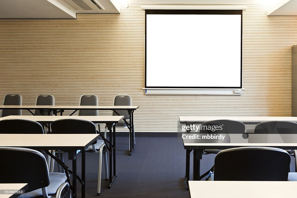 Empty lecture hall with blank projection screen