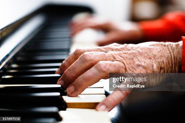 wrinkled hands of an old person play the piano - piano stockfoto's en -beelden