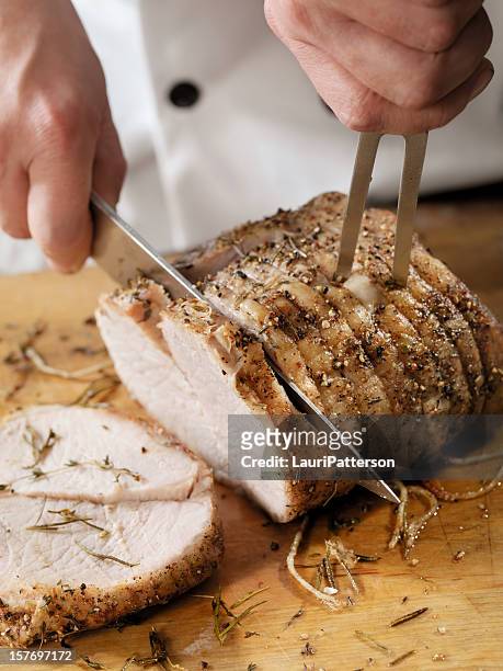 chef carving a pork roast - carvery stockfoto's en -beelden