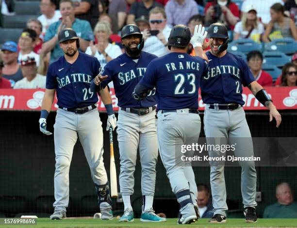 Ty France of the Seattle Mariners is congratulated by Tom Murphy and Teoscar Hernandez after hitting a three-run home run against Reid Detmers of the...