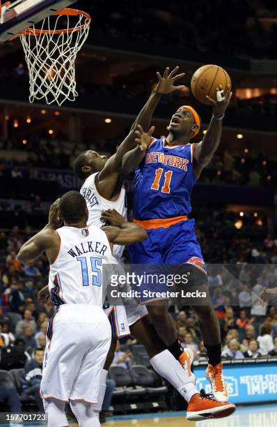 Michael Kidd-Gilchrist of the Charlotte Bobcats tries to block Ronnie Brewer of the New York Knicks during their game at Time Warner Cable Arena on...