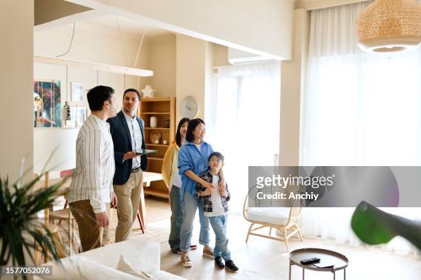 real estate agent talking with family - apartment tour stock pictures, royalty-free photos & images