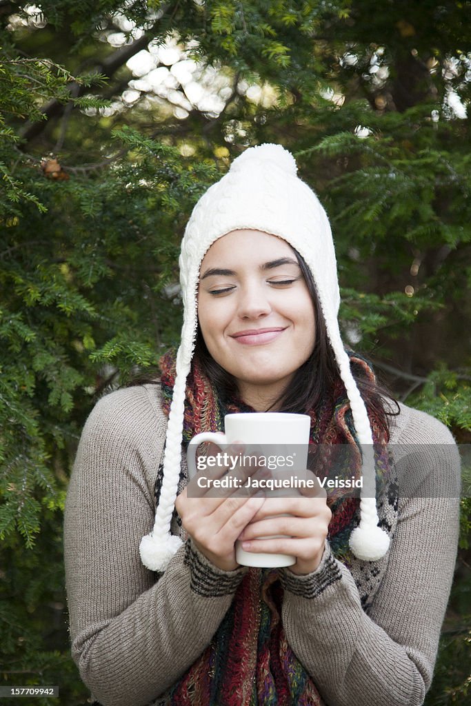 Woman in winter holding mug of hot chocolate