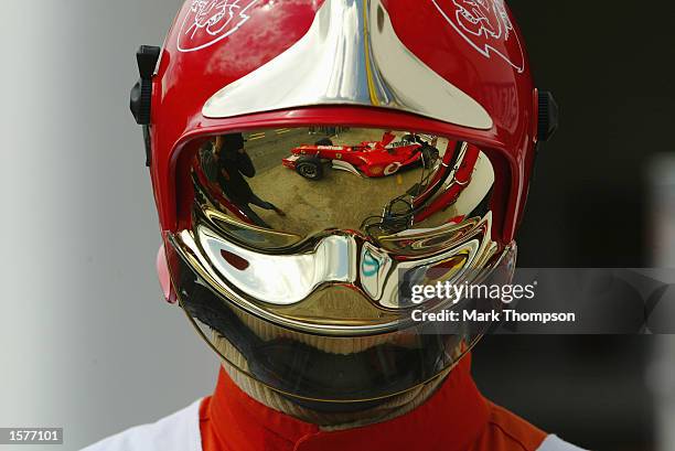 Rubens Barrichello of Brazil and Ferrari leaves the garage in the reflection of a fire marshal's visor during qualifying for the Formula One San...