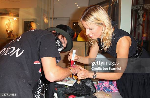 Artist Alec Monopoly and model Karolina Kurkova attend the Haute Living and Roger Dubuis dinner hosted by Daphne Guinness at Azur on December 5, 2012...