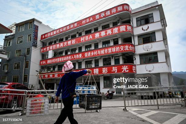 This photo taken on July 30, 2023 shows banners promoting the grassroots basketball competition CunBA hanging from a building in Taipan village,...